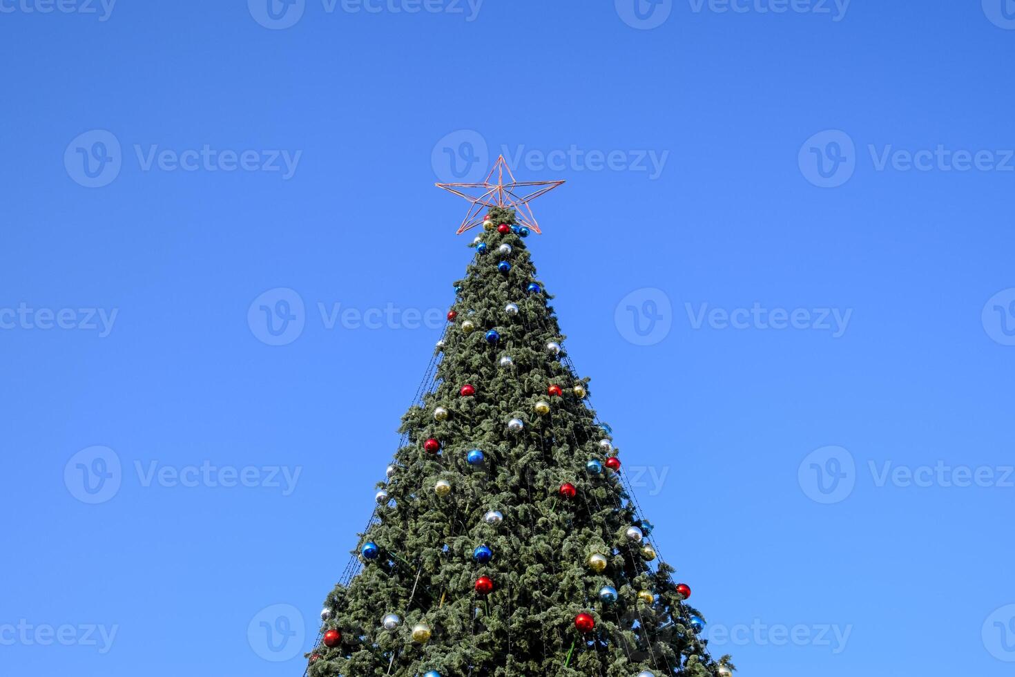 Decorations New Year tree. Tinsel and toys, balls and other decorations on the Christmas Christmas tree standing in the open air. photo