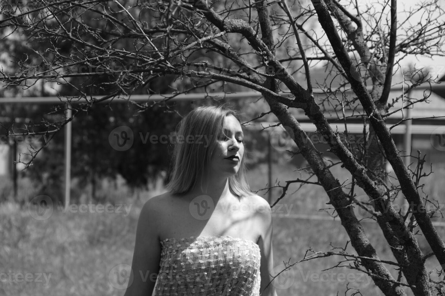negro y blanco foto, niña en el jardín en un prado en un vestido. foto