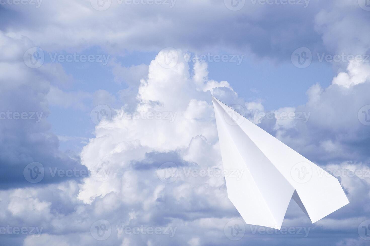 White paper airplane in a blue sky with clouds. The message symbol in the messenger photo