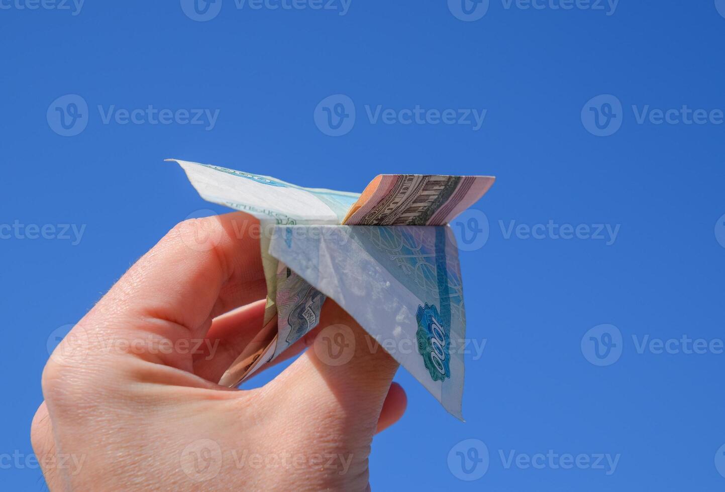 denominaciones de ruso dinero, doblada en el avión en contra el azul cielo en mano foto