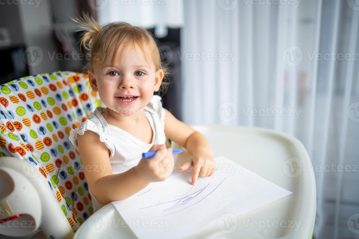 Cute little girl painting with felt-tip pen at home. Creative games for kids. Stay at home entertainment photo