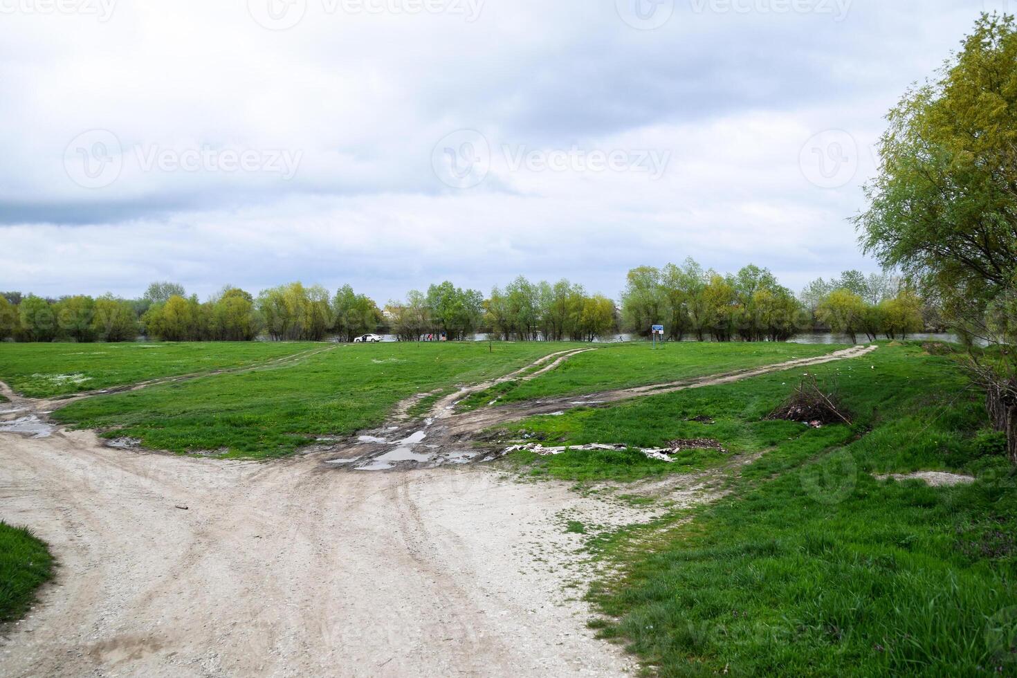The fork of several dirt roads near river. photo