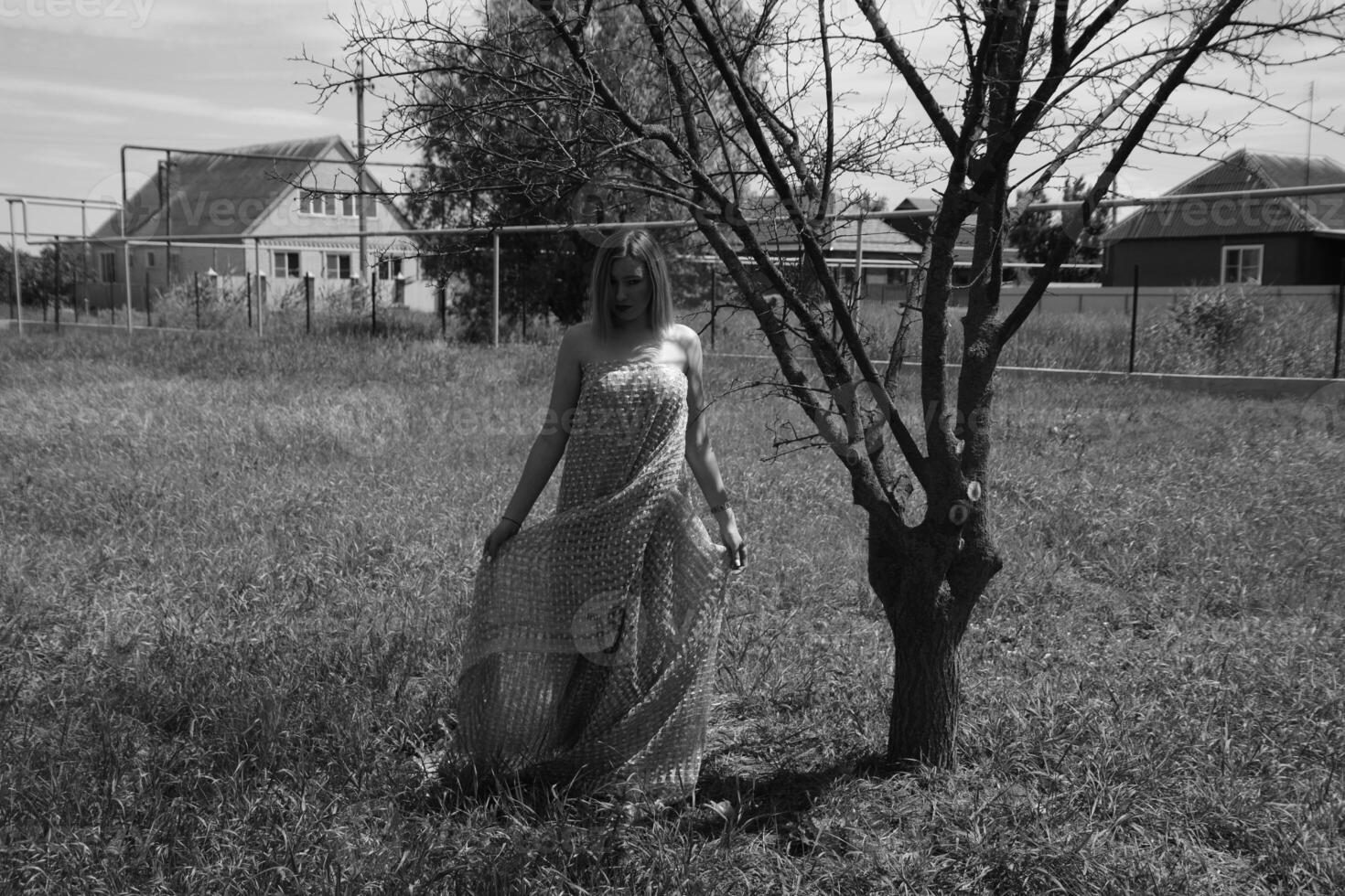 negro y blanco foto, niña en el jardín en un prado en un vestido. foto