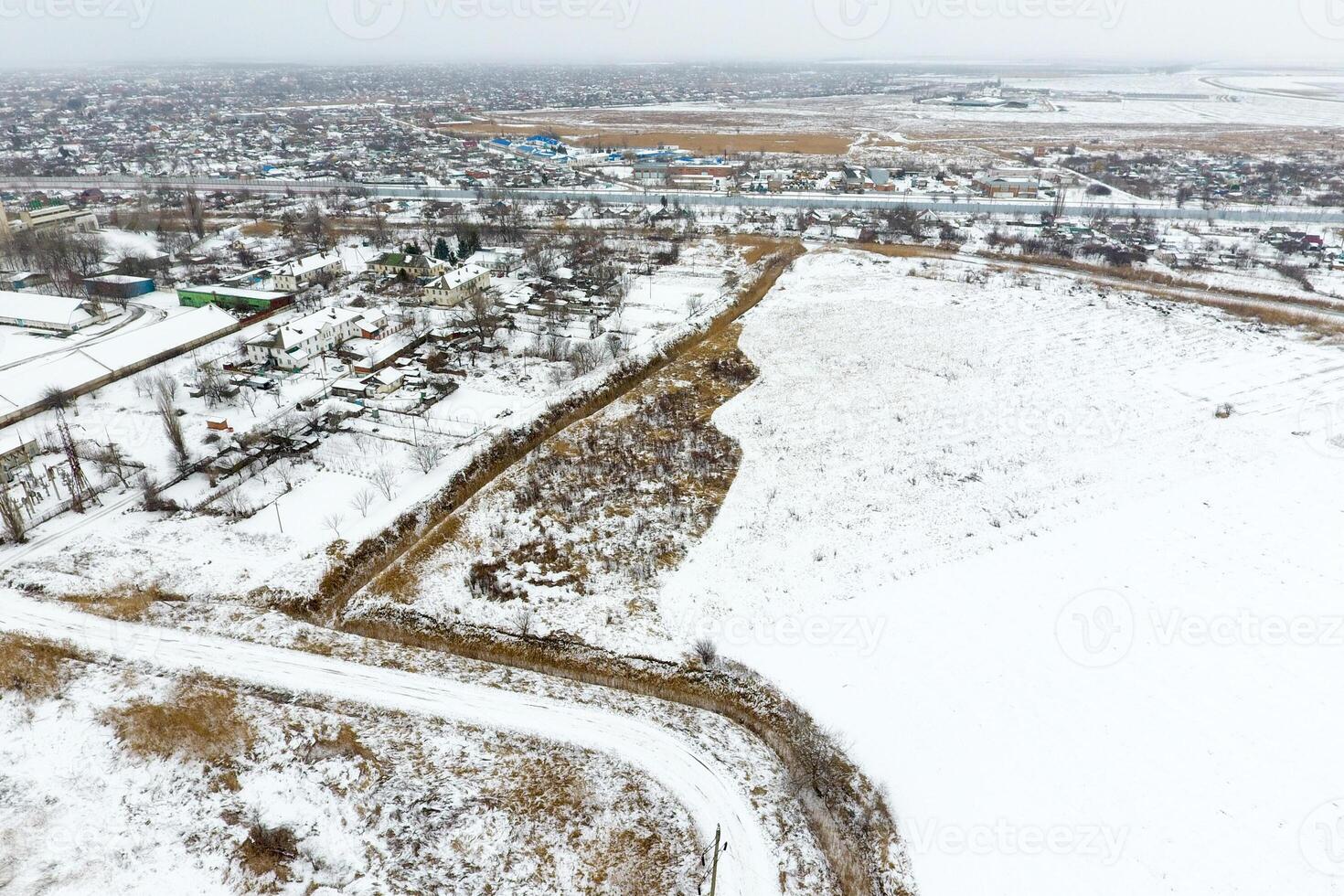 Sprinkled with snow grain elevator. Winter view of the old Soviet elevator. Winter view from the bird's eye view of the village. The streets are covered with snow photo