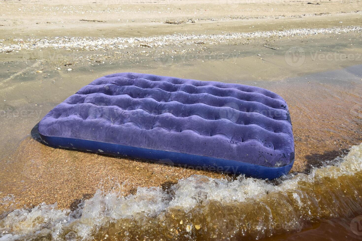 Blue inflatable mattress swimming in the pond photo