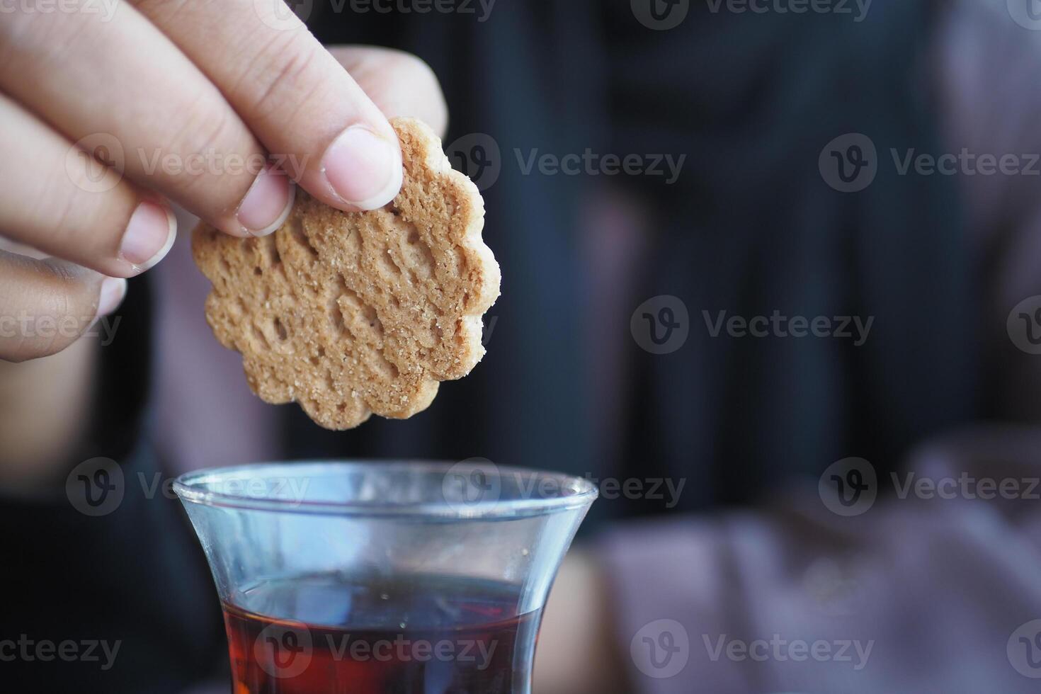 pouring sweet cookies in a tea cup photo