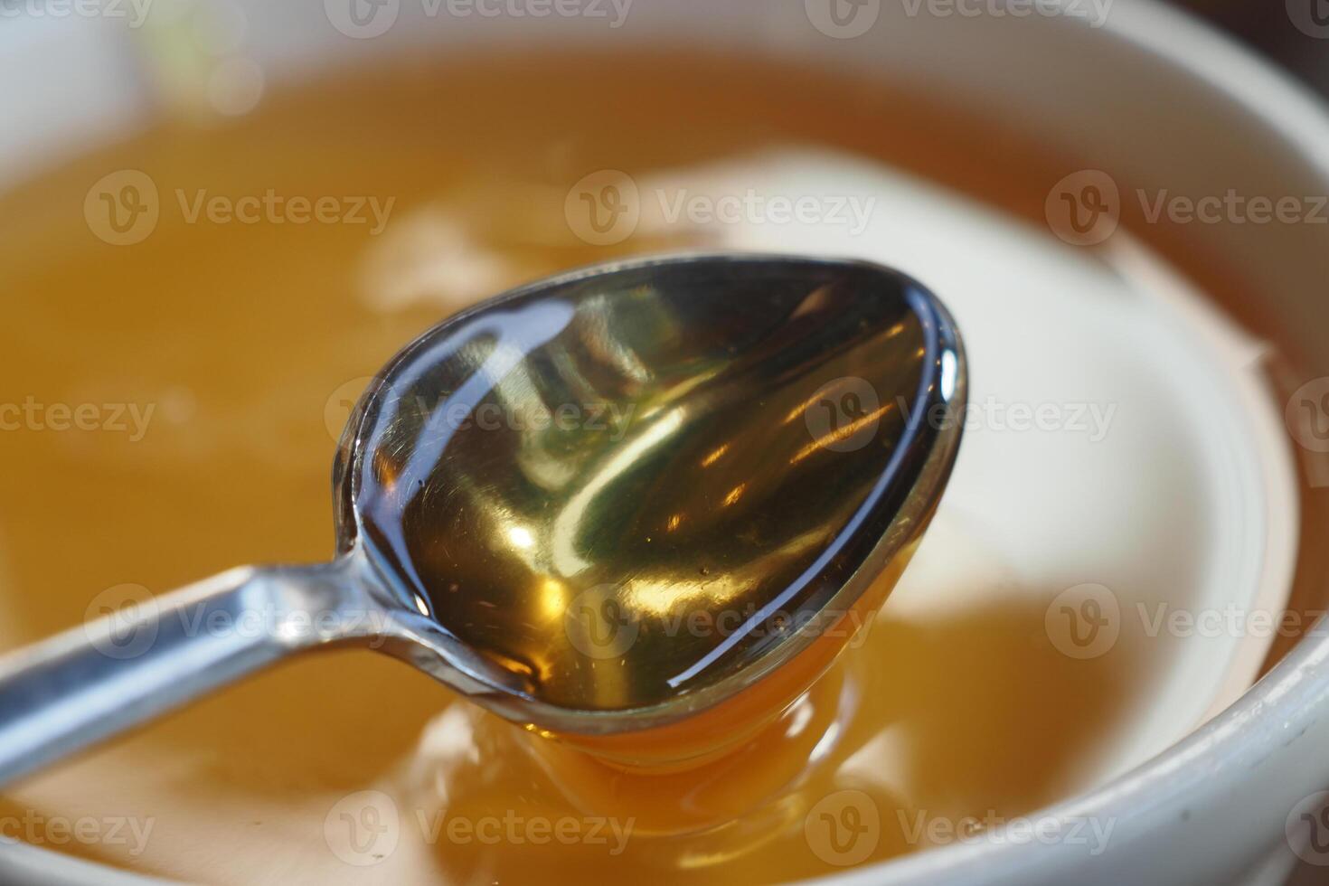 close up of fresh honey with spoon on table photo