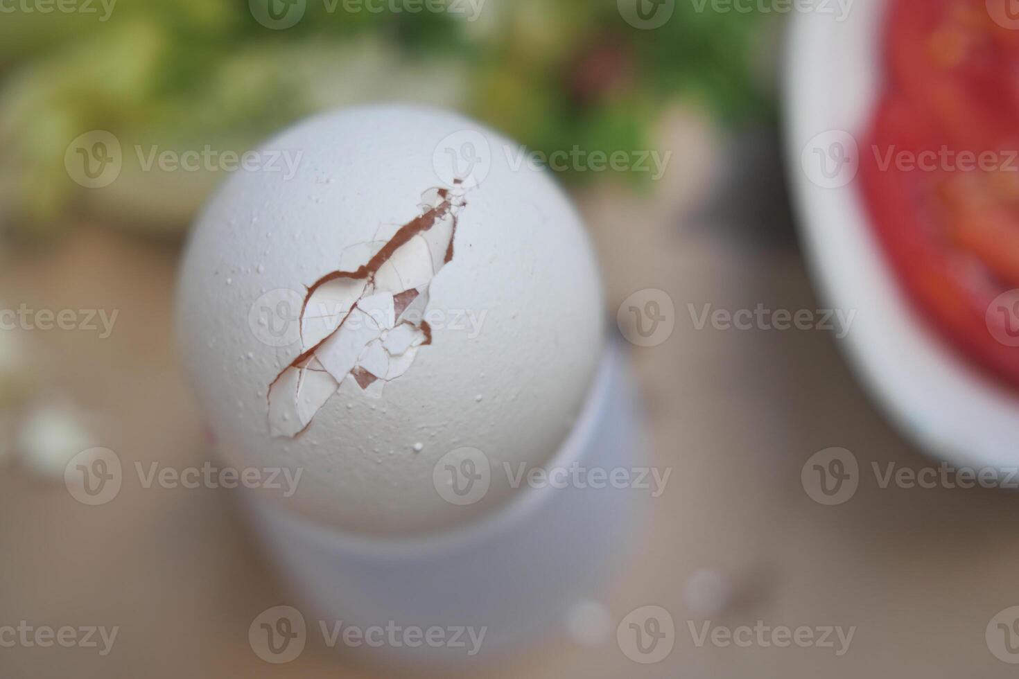 one broken egg with yellow yolk stored in carton container photo