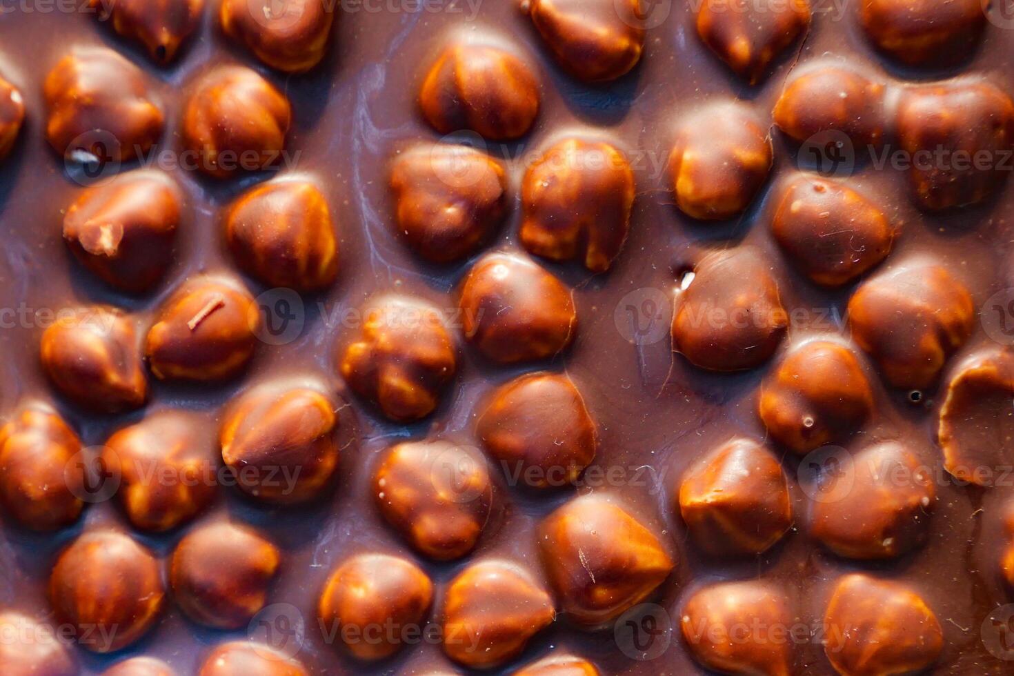 Milk chocolate with crashed hazelnuts background photo