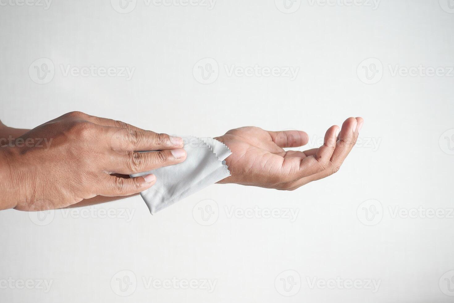 man disinfecting his hands with a wet wipe. photo