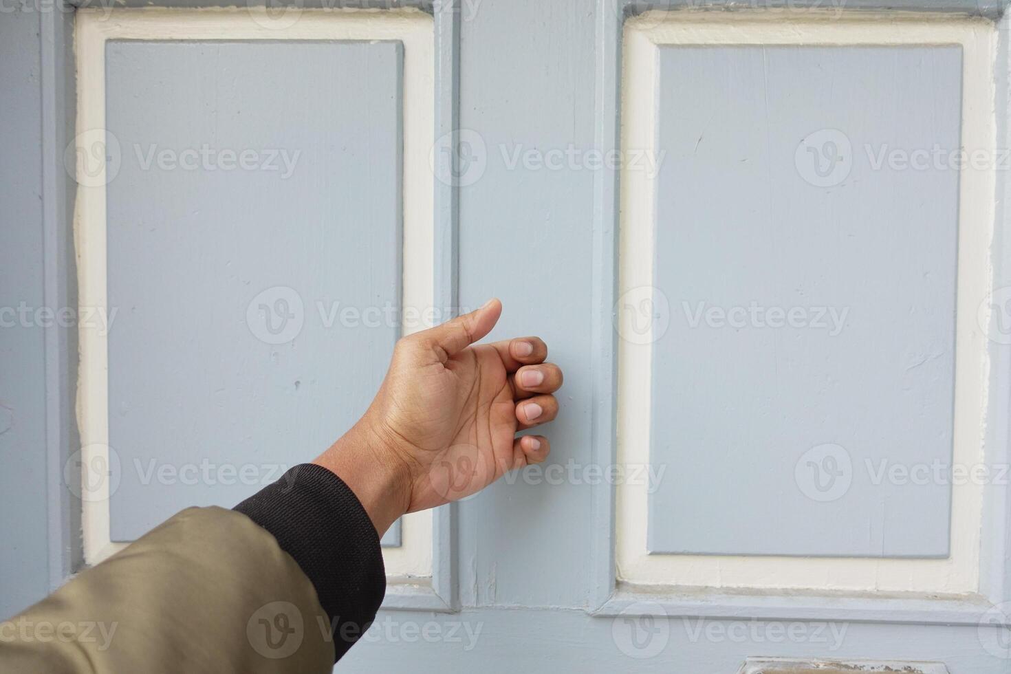 young man hand knocking door, photo