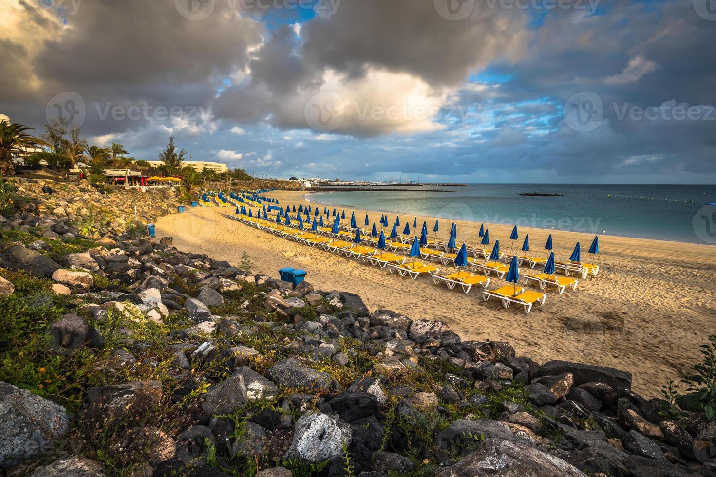 Beautiful sun loungers with parasols on the beach photo