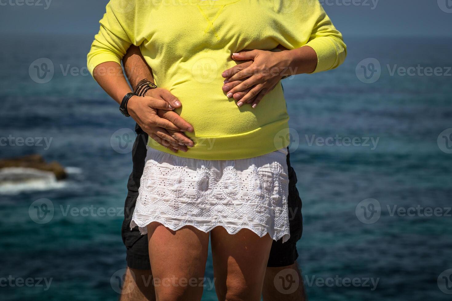 embarazada mujer y su marido participación su manos en su bebé bache foto