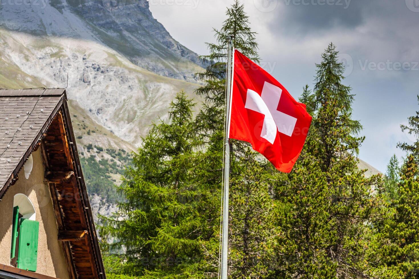 Swiss flag - national symbol of Switzerland with Alps in background photo