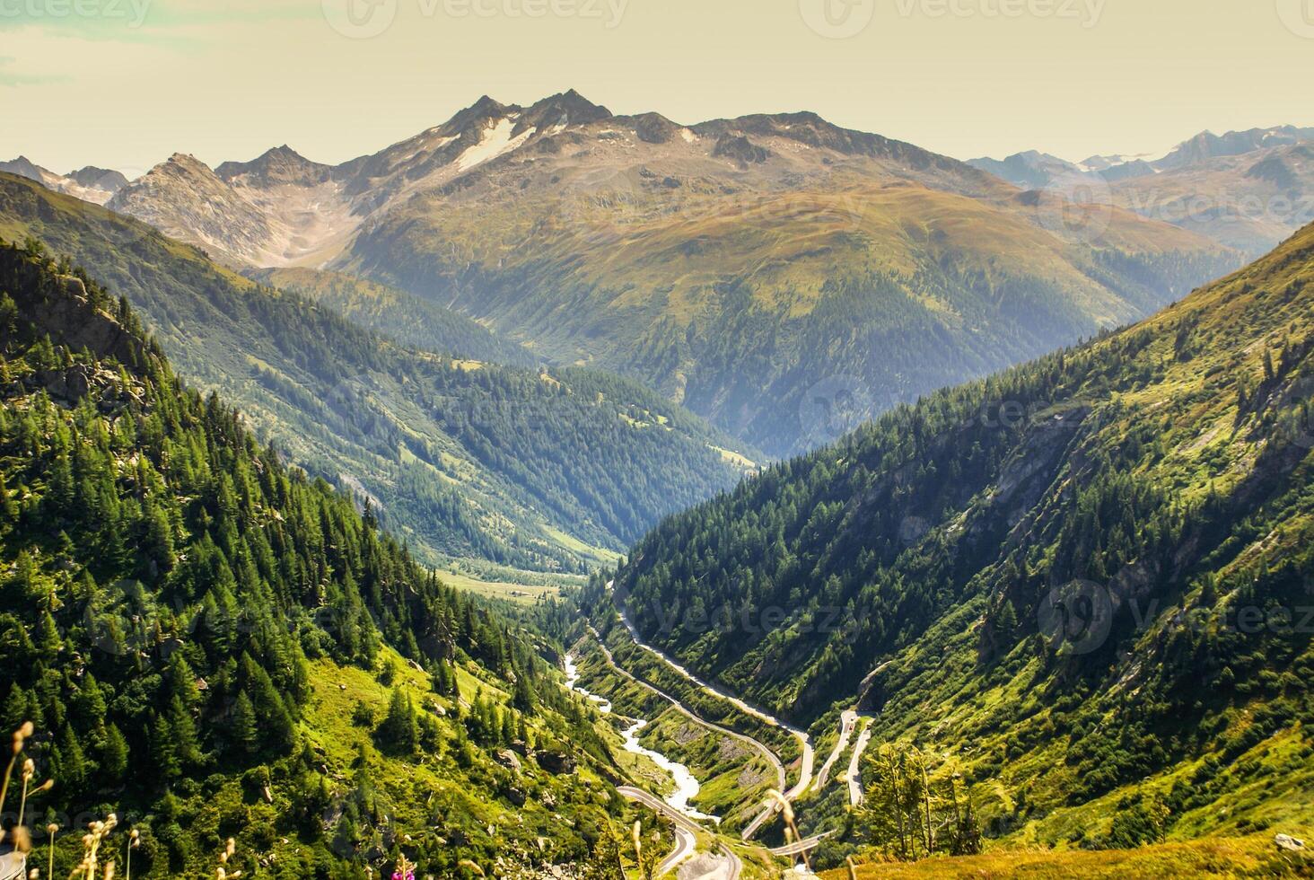 View through Alps valley near Gletch with Furka pass mountain road, Switzerland photo