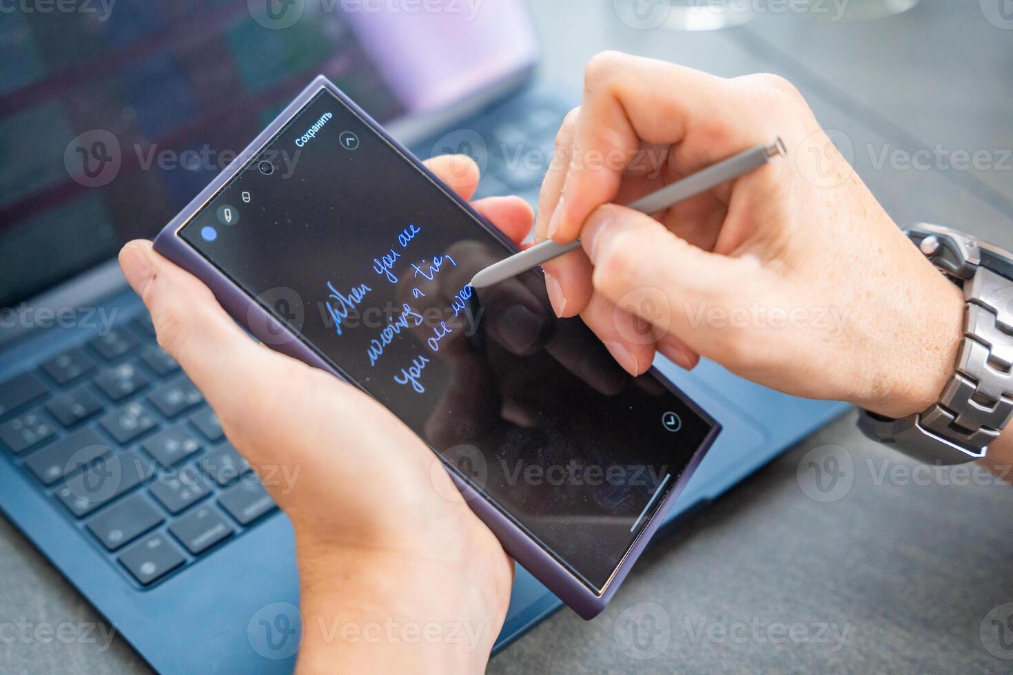 Close up view of man hand holding smart phone and stylus pen at his creative workspace. photo