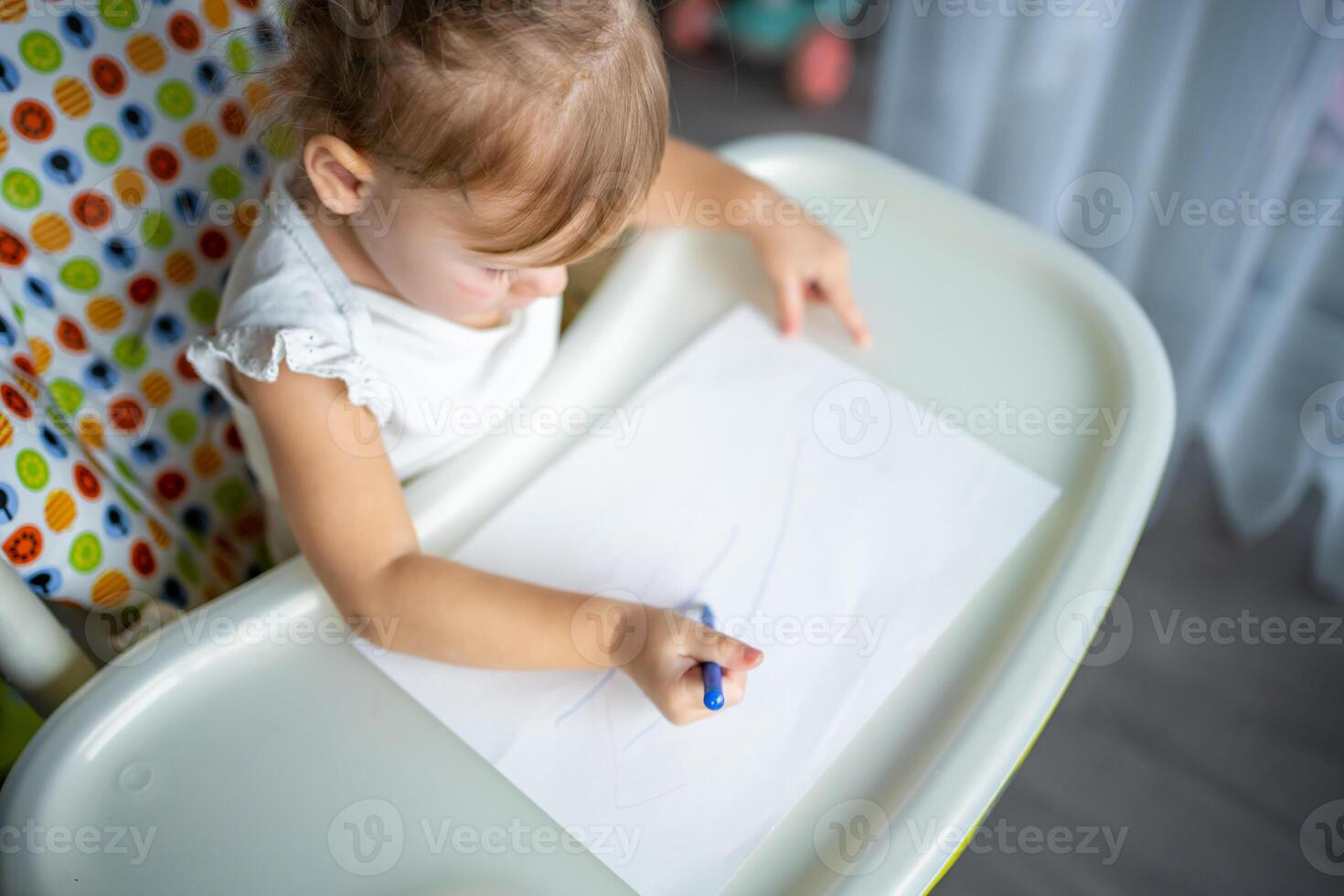 Cute little girl painting with felt-tip pen at home. Creative games for kids. Stay at home entertainment photo