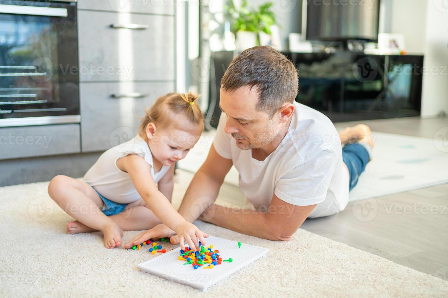 linda pequeño niña jugando con seta uña mosaico. padre y bebé jugando juntos concepto. pasatiempo y ocio tiempo. foto