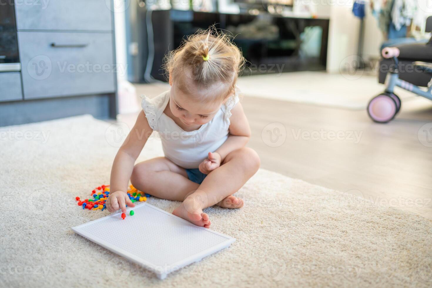 Pretty little girl playing with mushroom nail mosaic at home. Hobby and leisure time photo