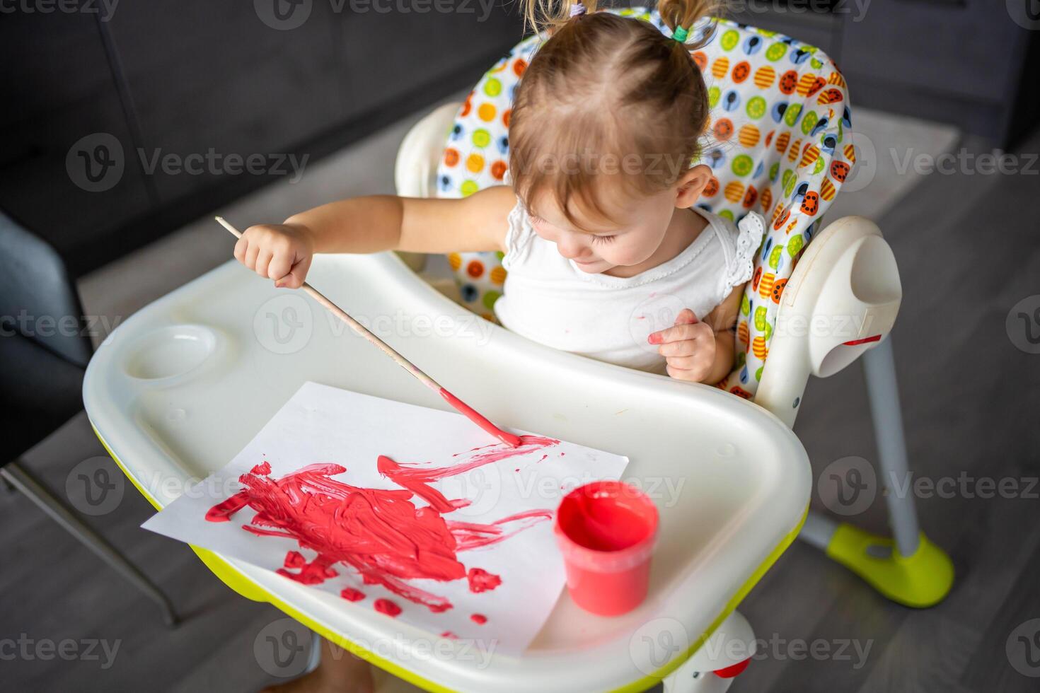 Cute little girl painting with brushes at home. Creative games for kids. Stay at home entertainment photo