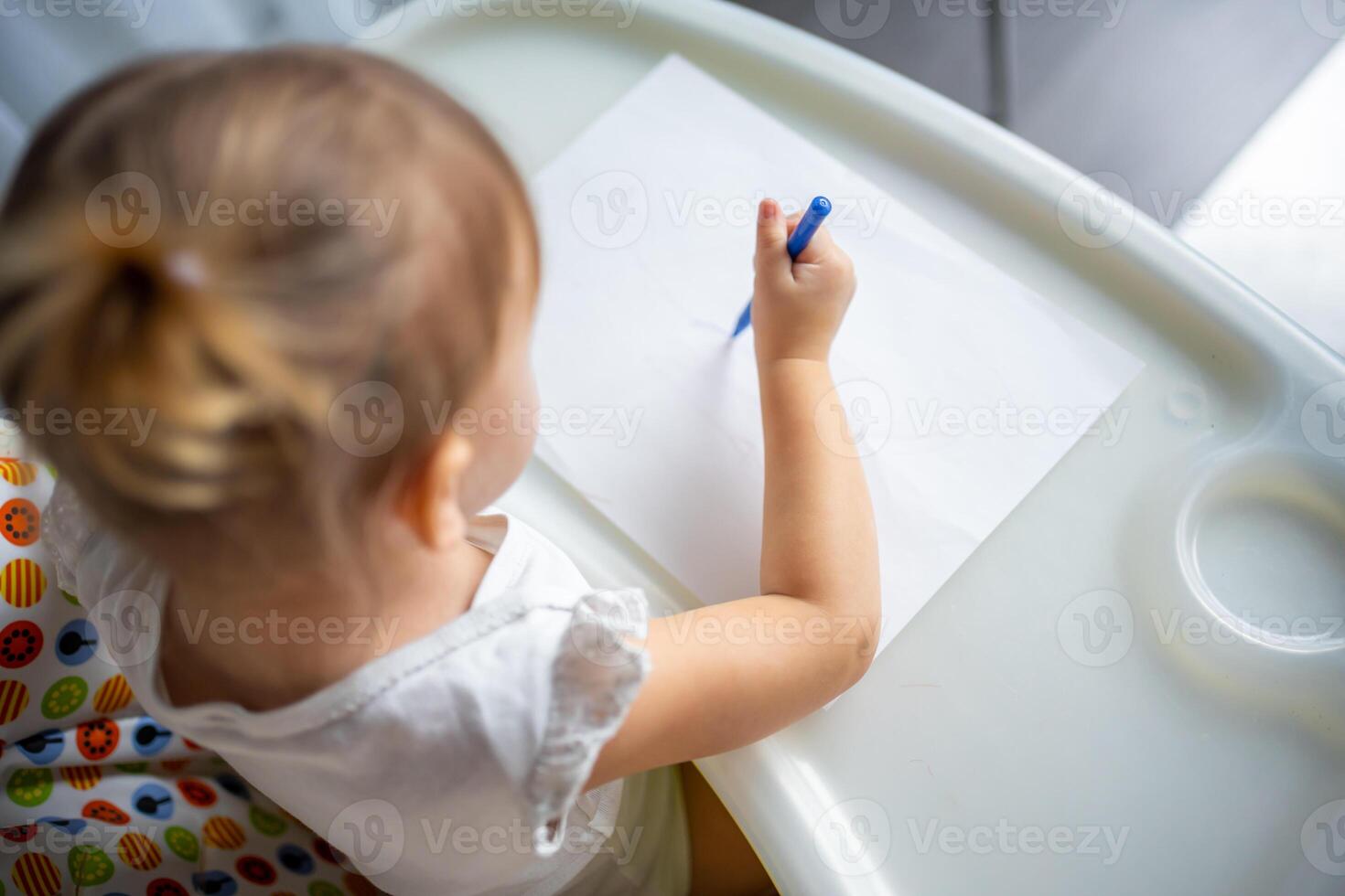 Cute little girl painting with felt-tip pen at home. Creative games for kids. Stay at home entertainment photo