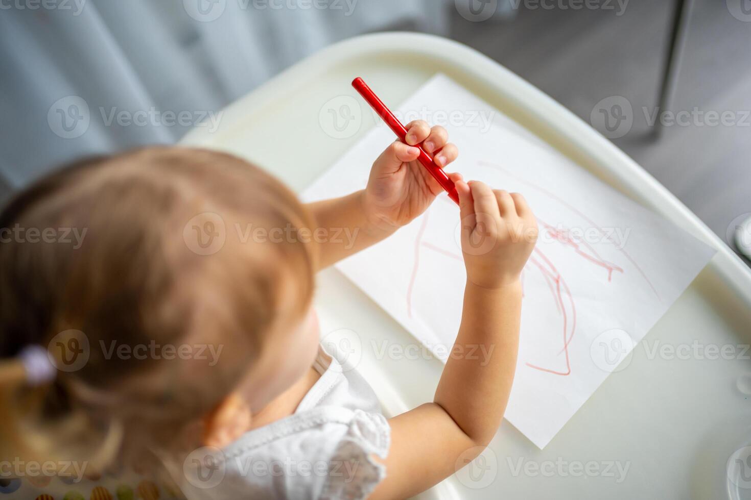 Cute little girl painting with felt-tip pen at home. Creative games for kids. Stay at home entertainment photo