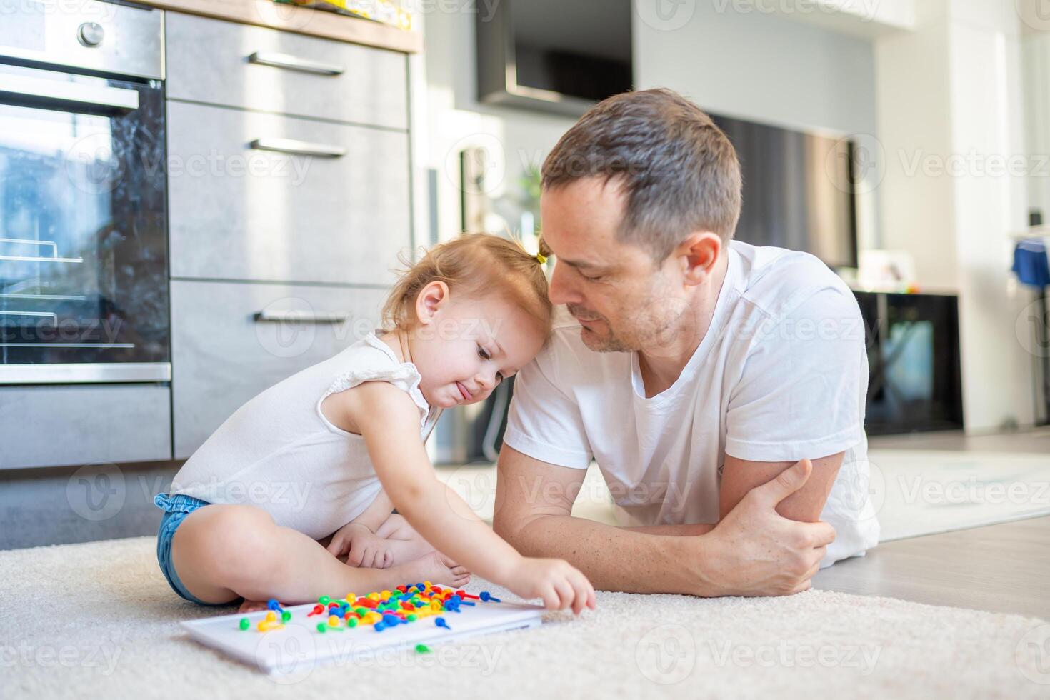 linda pequeño niña jugando con seta uña mosaico. padre y bebé jugando juntos concepto. pasatiempo y ocio tiempo. foto