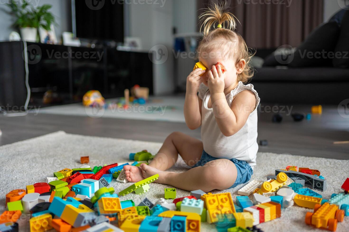 Caucasian child a little girl is playing in the constructor at home. Educational toys for children. photo