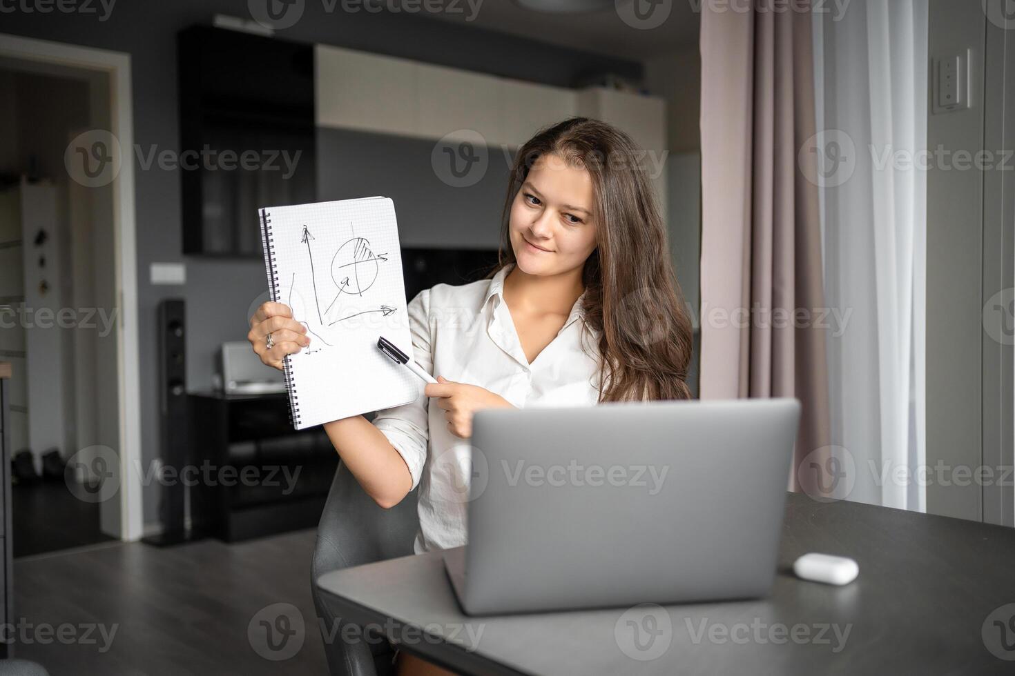 Female teacher having video conference chat with student or class group, using laptop. Woman talking to webcam, explaining. Online Education concept photo