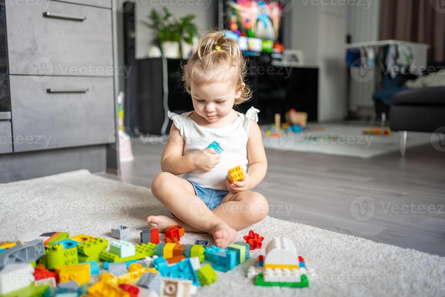 Caucasian child a little girl is playing in the constructor at home. Educational toys for children. photo