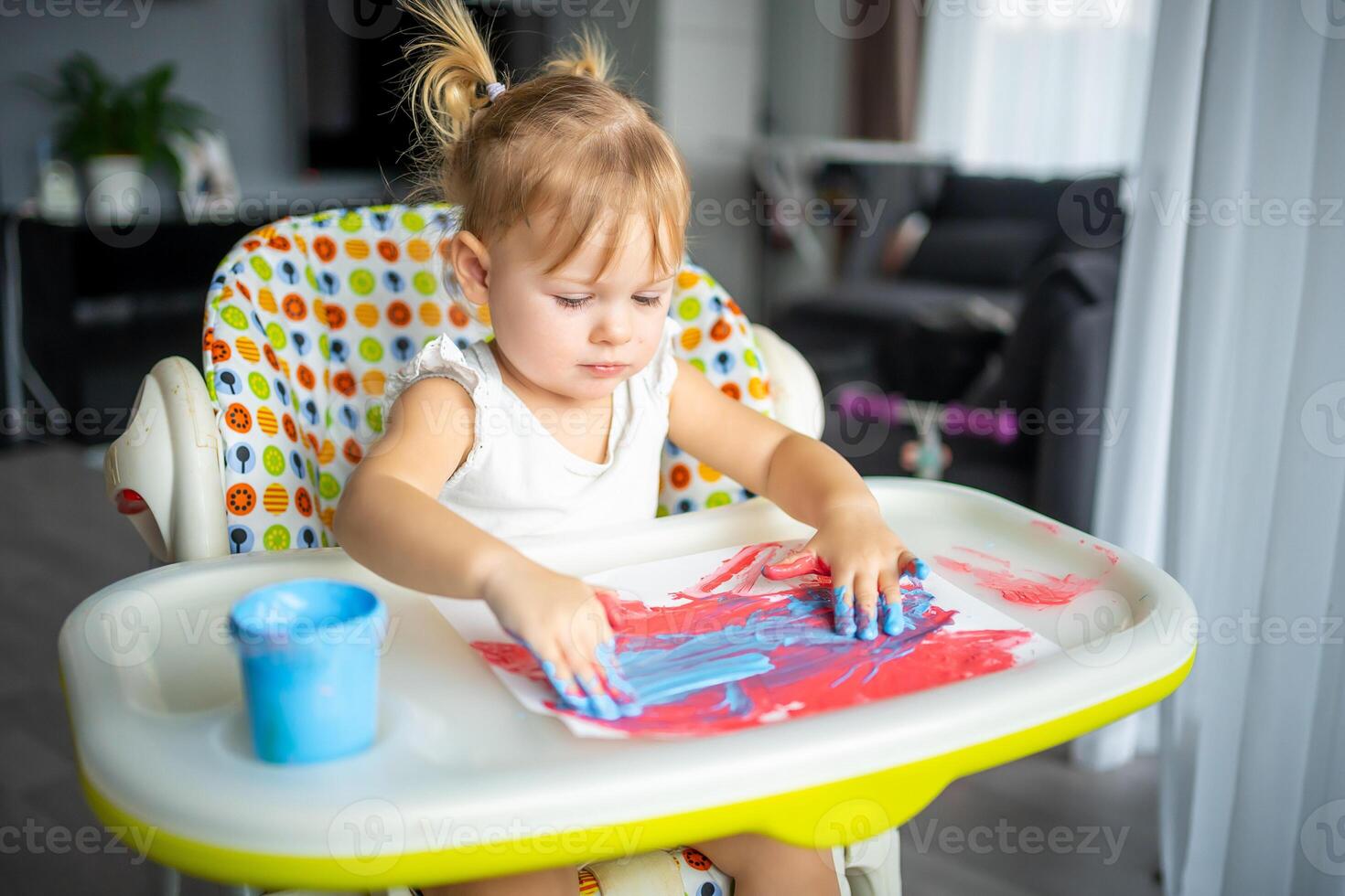 Cute little girl painting with fingers at home. Creative games for kids. Stay at home entertainment photo