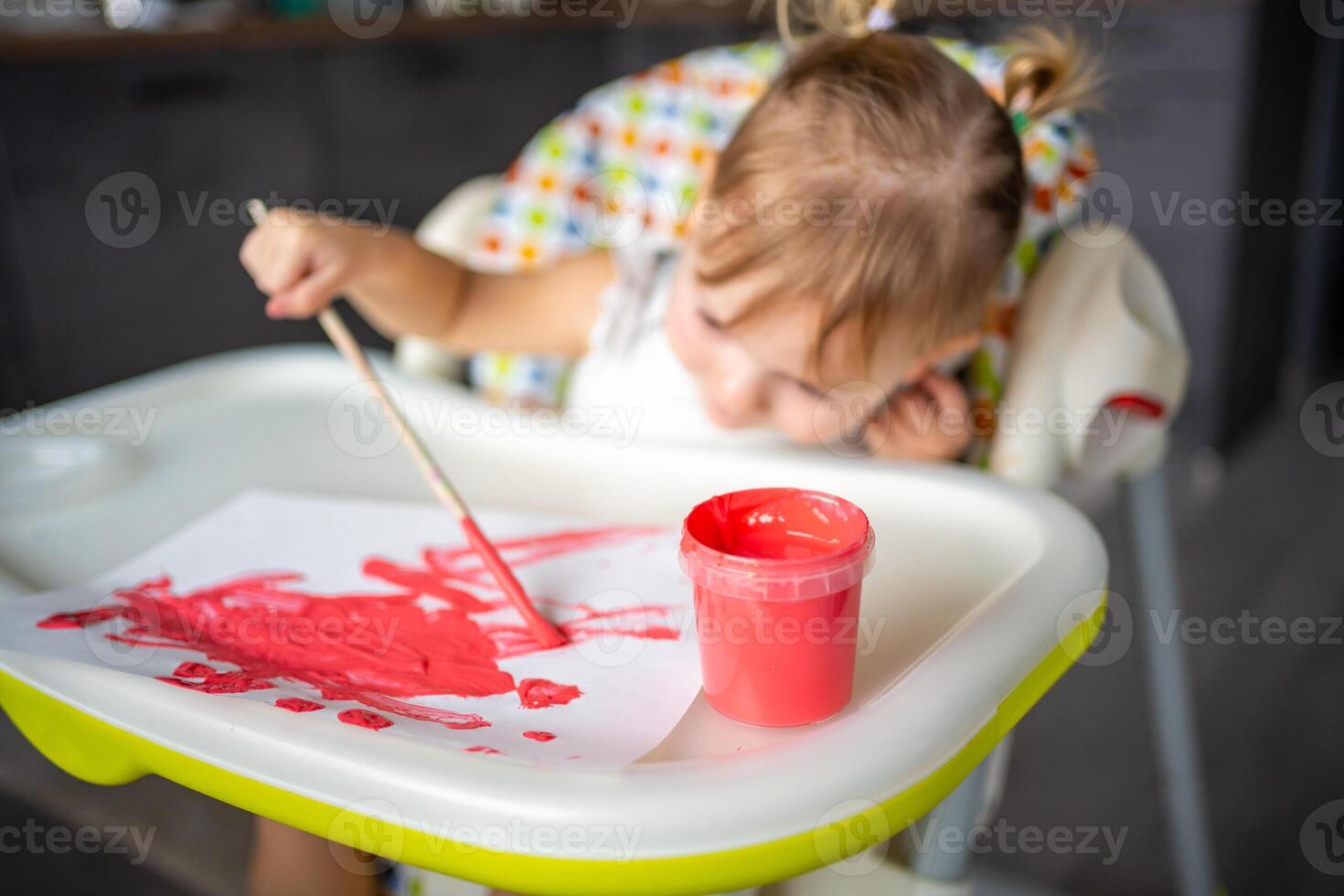 Cute little girl painting with brushes at home. Creative games for kids. Stay at home entertainment photo