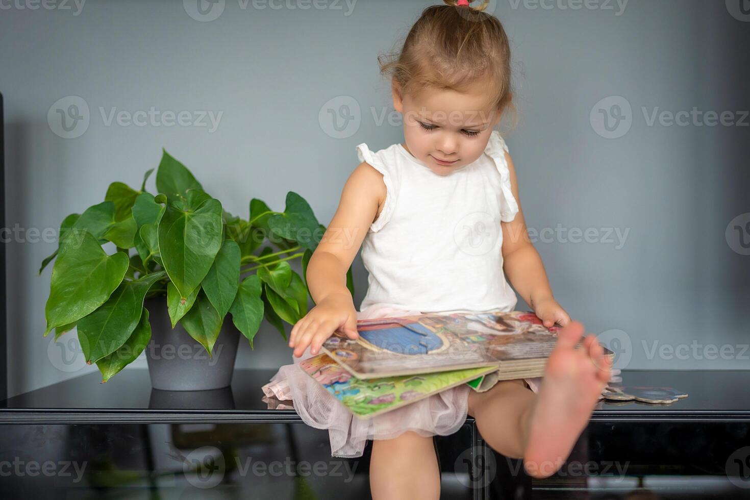 adorable niñito pequeño niña leyendo libro a hogar. felicidad niño leyendo libro para preescolar disfrutar con aprendizaje educación por tú mismo. educación concepto foto