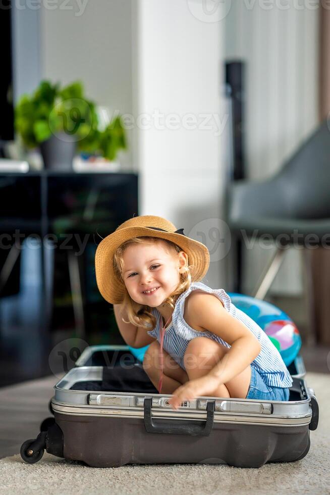 Little girl in suitcase baggage luggage ready to go for traveling on vacation photo