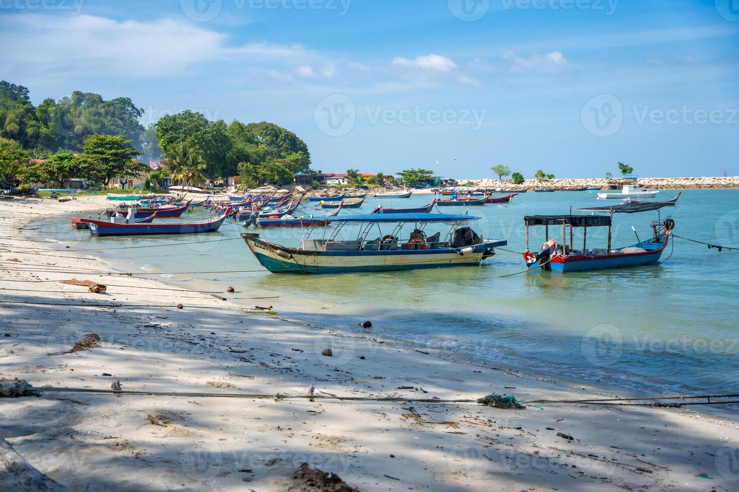 Fishing boats on the sea and beach of George Town city in the distance on the Strait of Malacca in Penang, Malaysia. photo