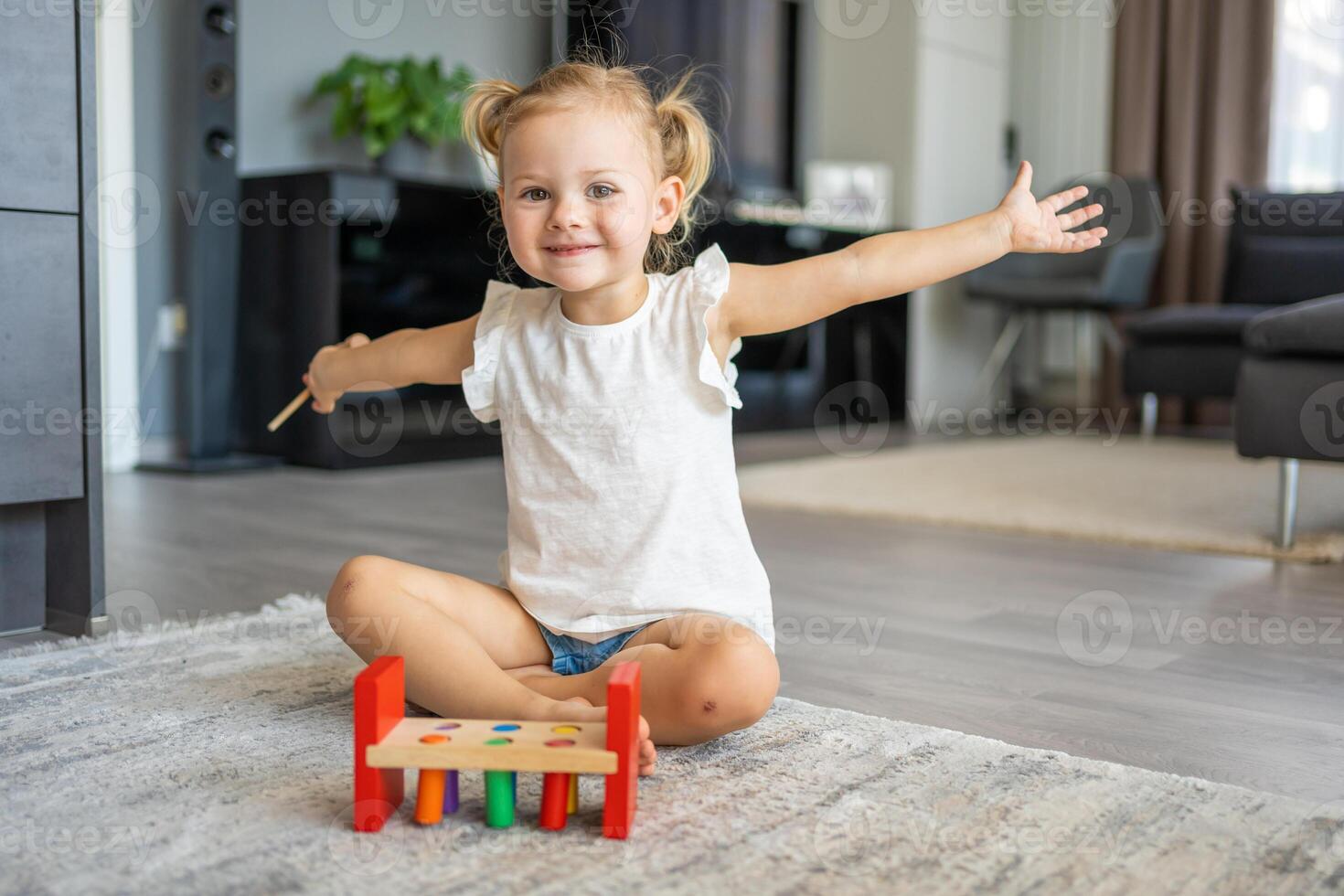 linda caucásico pequeño niña jugando en el piso a hogar con eco de madera juguetes montessori juguete. el niño jugando educativo juegos. foto