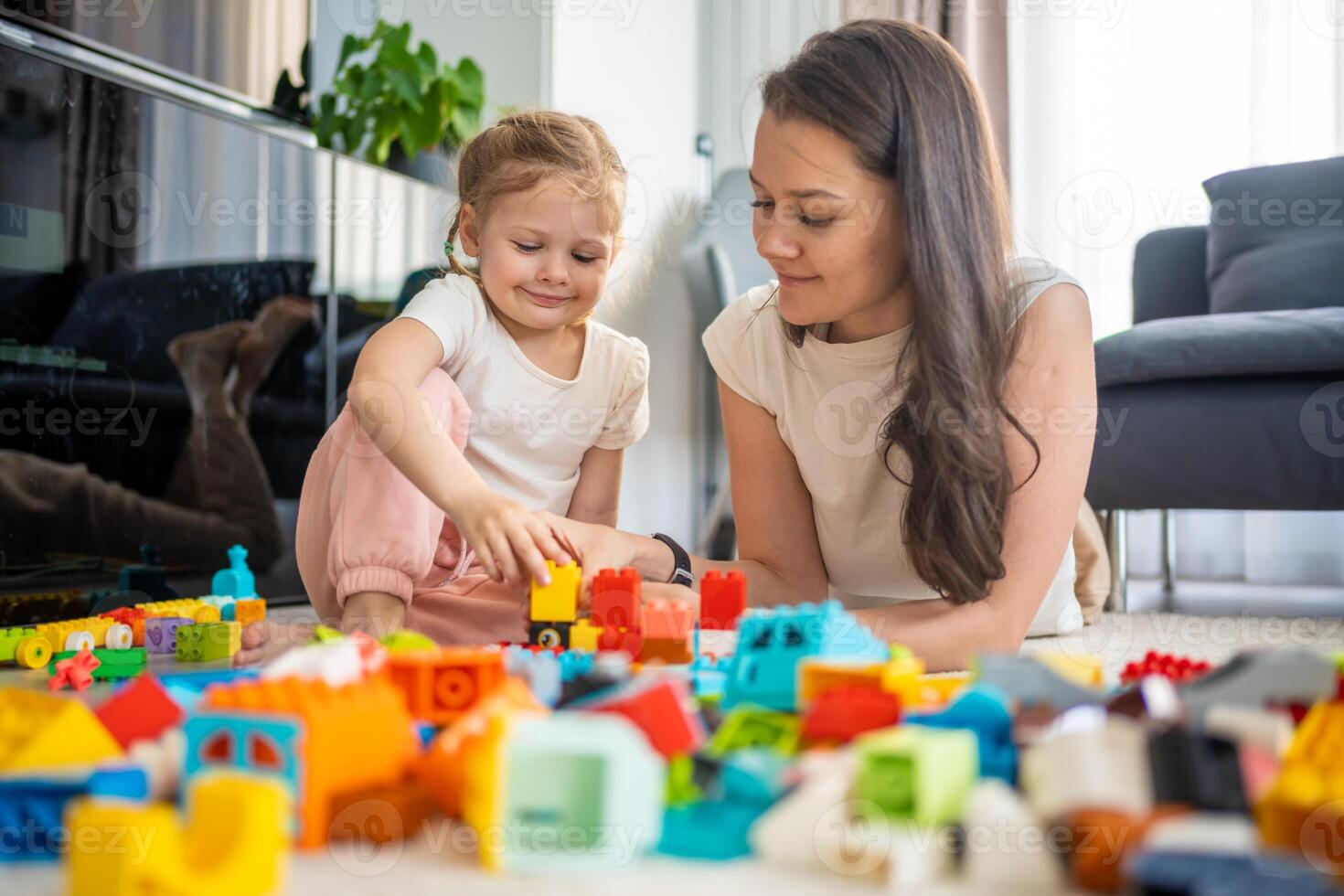 Little girl play with constructor toy on floor in home with mom or woman babysitter, educational game, family at home spend leisure activities time together concept photo