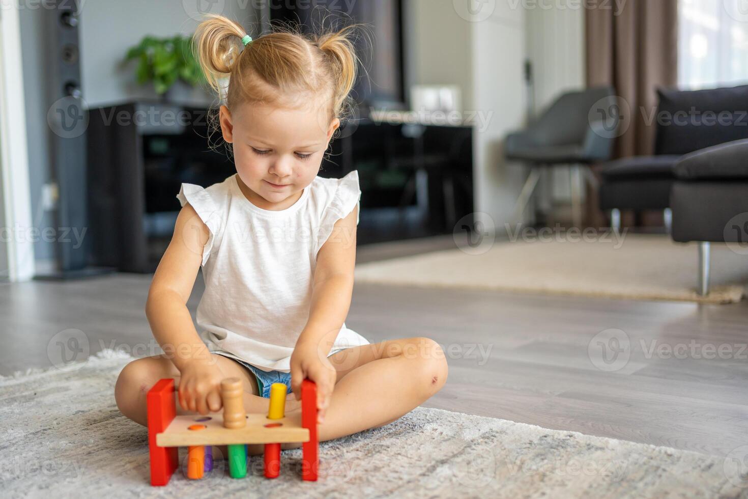 linda caucásico pequeño niña jugando en el piso a hogar con eco de madera juguetes el niño jugando educativo juegos. foto