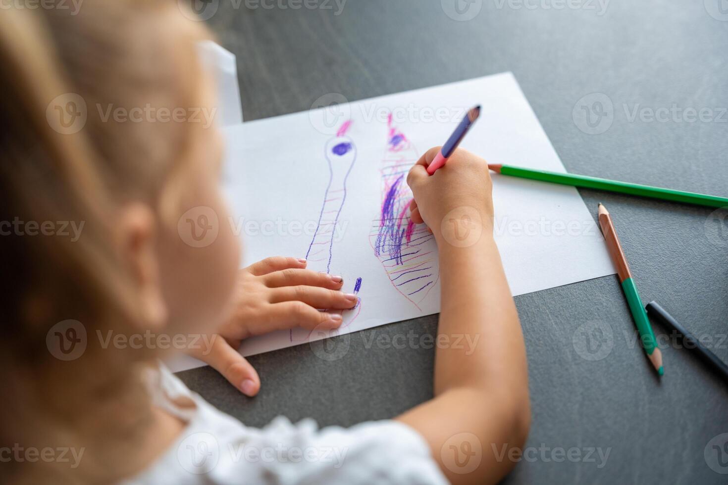 pequeño niña sorteos con de colores lapices en hogar. foto