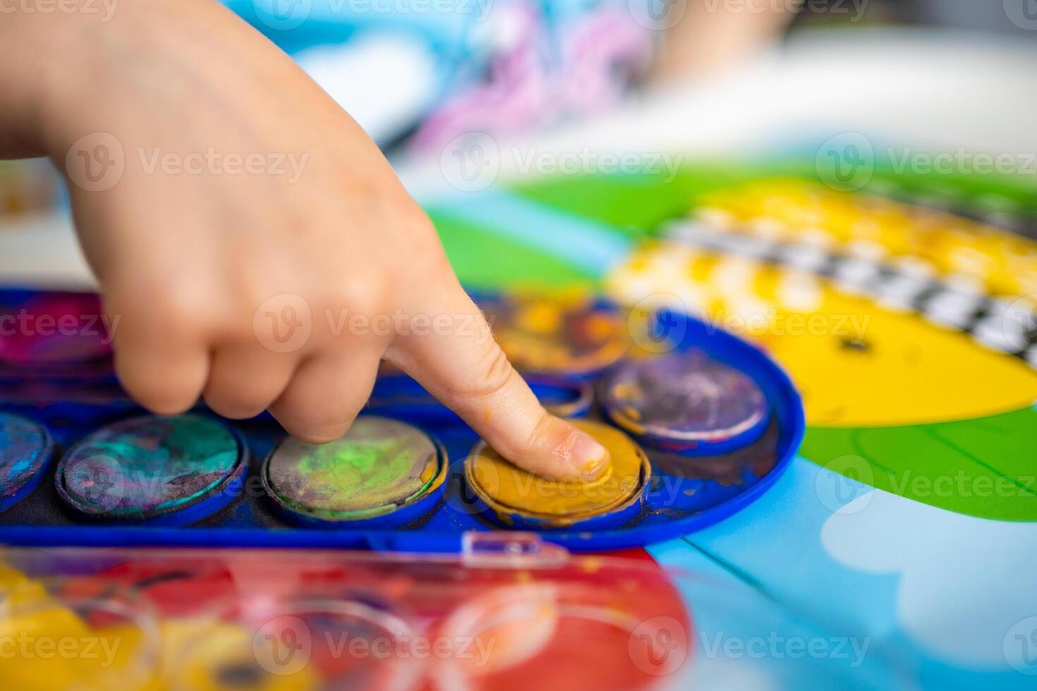 The child fills in the empty spaces. Ideas for finger painting. Finger painting task for kids. Little girl draws with paints. children development concept. photo