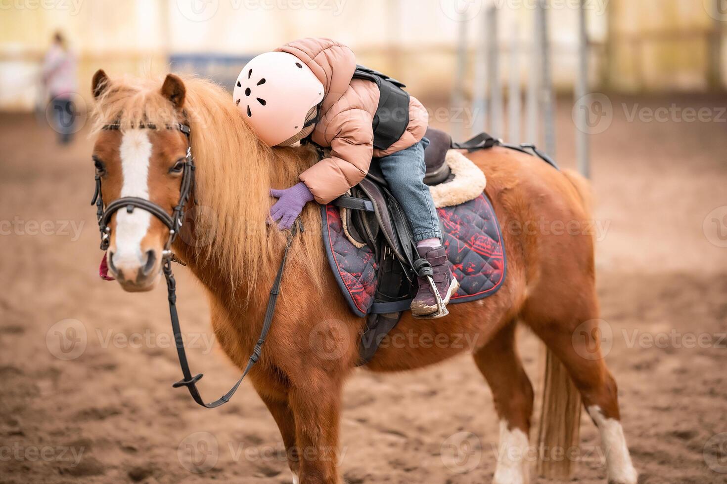 Little Child Riding Lesson. Three-year-old girl rides a pony and does exercises. High quality photo