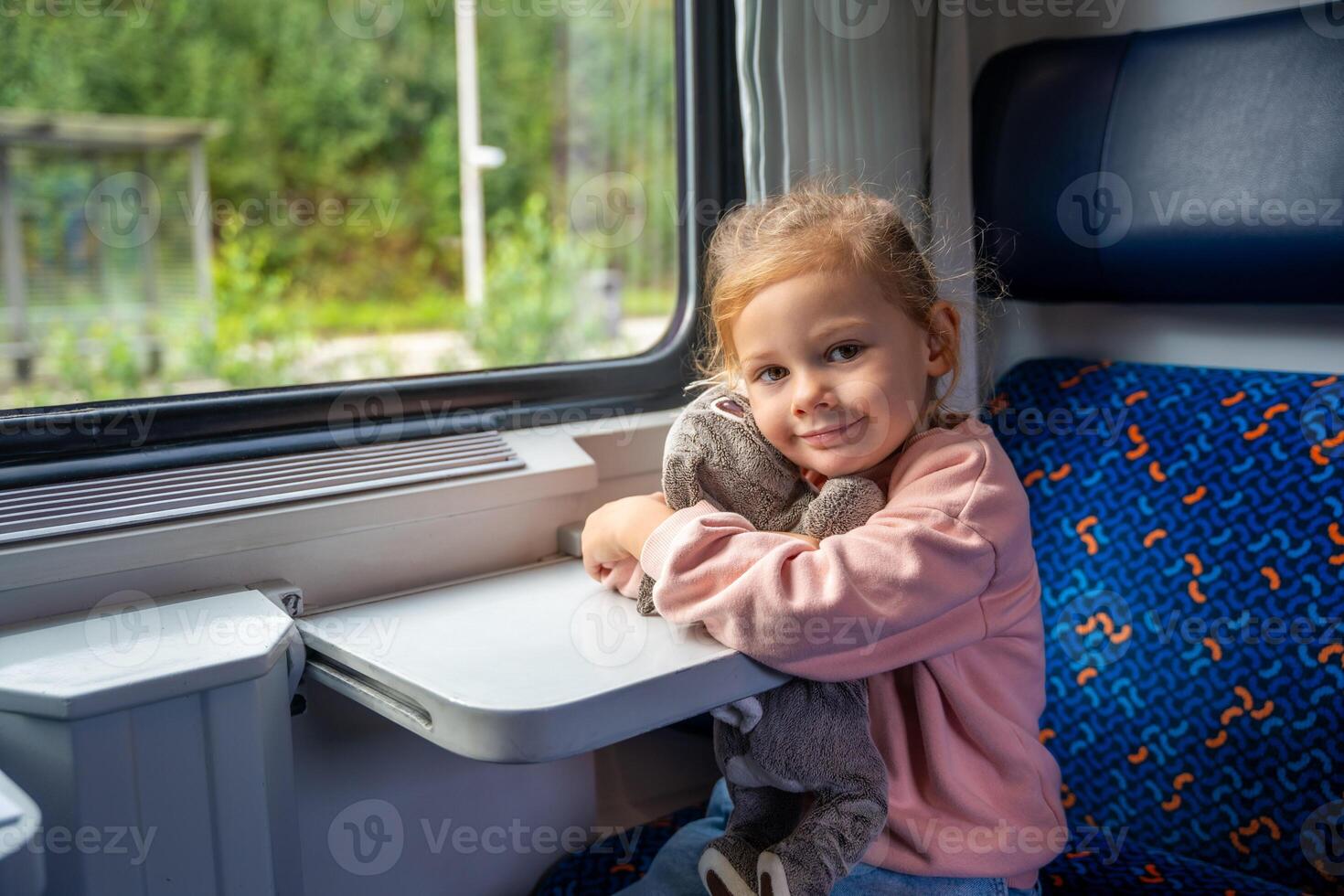 Beautiful little girl near train window, during traveling by railway in Europe photo