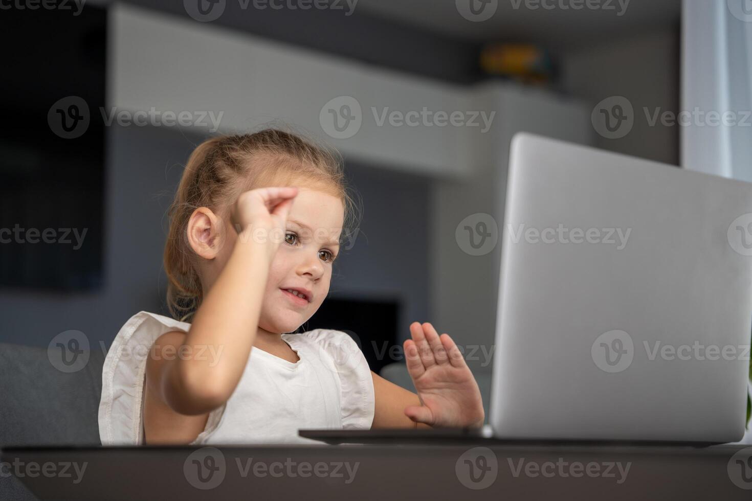pequeño niña lo hace dedo gimnasia en línea en el ordenador portátil hogar. distancia aprendizaje concepto. foto