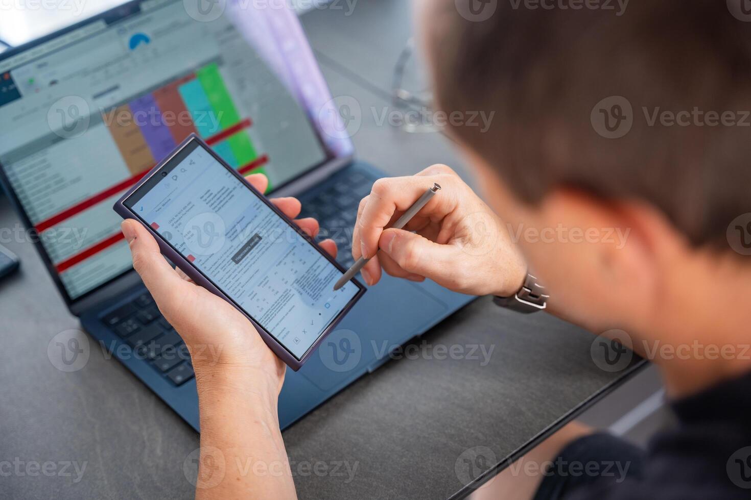 Close up view of man hand holding smart phone and stylus pen at his creative workspace. photo