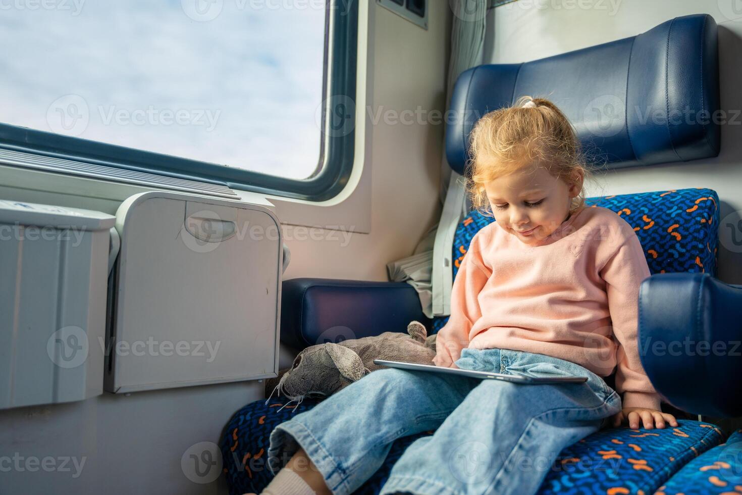 Cute Little girl using digital tablet during traveling by railway, Europe photo