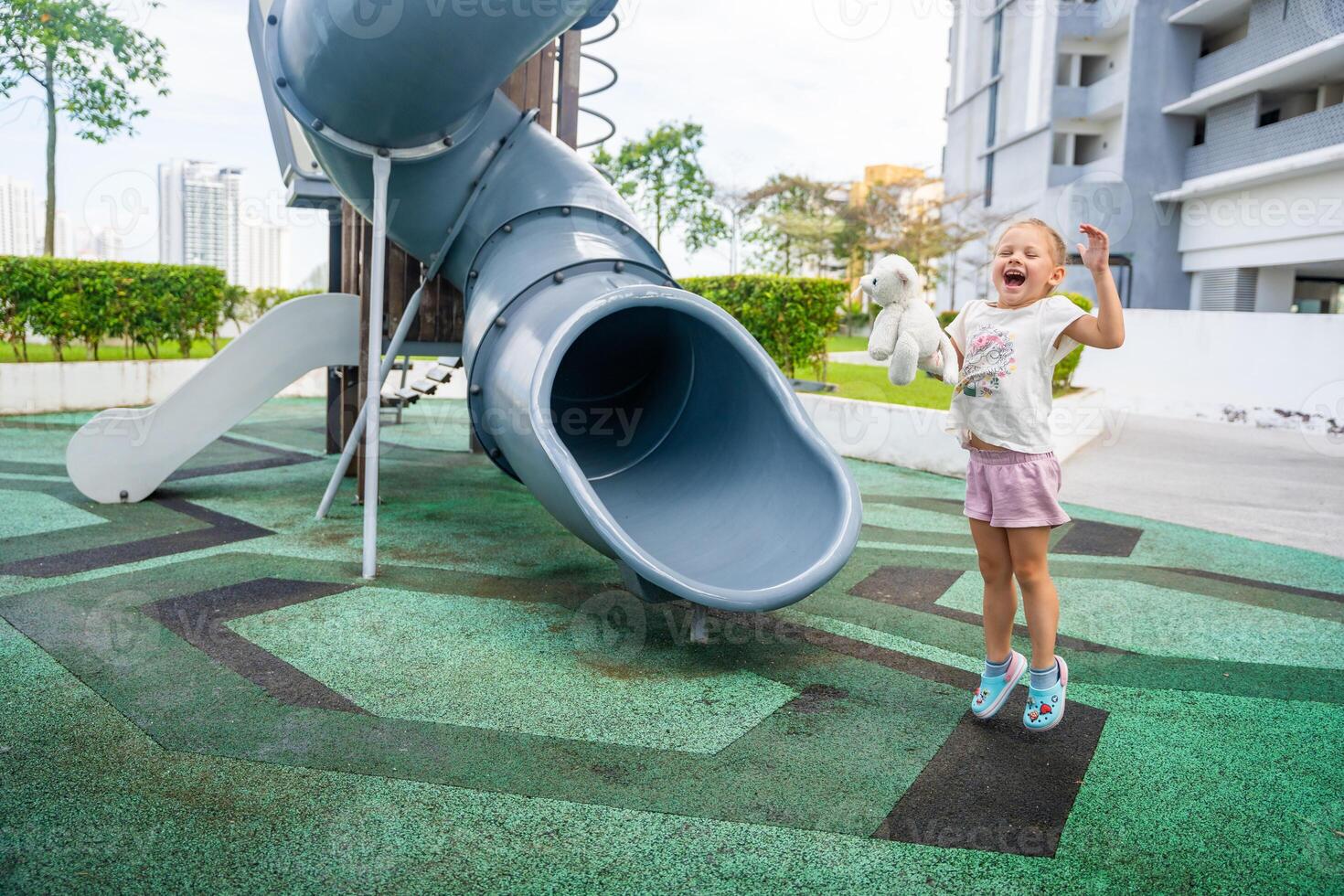 contento pequeño niña en patio de recreo en techo de uno de edificio en georgetown, Malasia, concepto para divertido y la seguridad de niños. foto