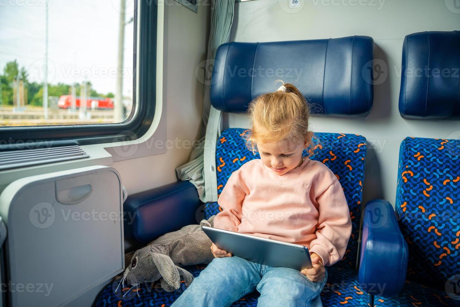 Little girl using digital tablet during traveling by railway, Europe photo