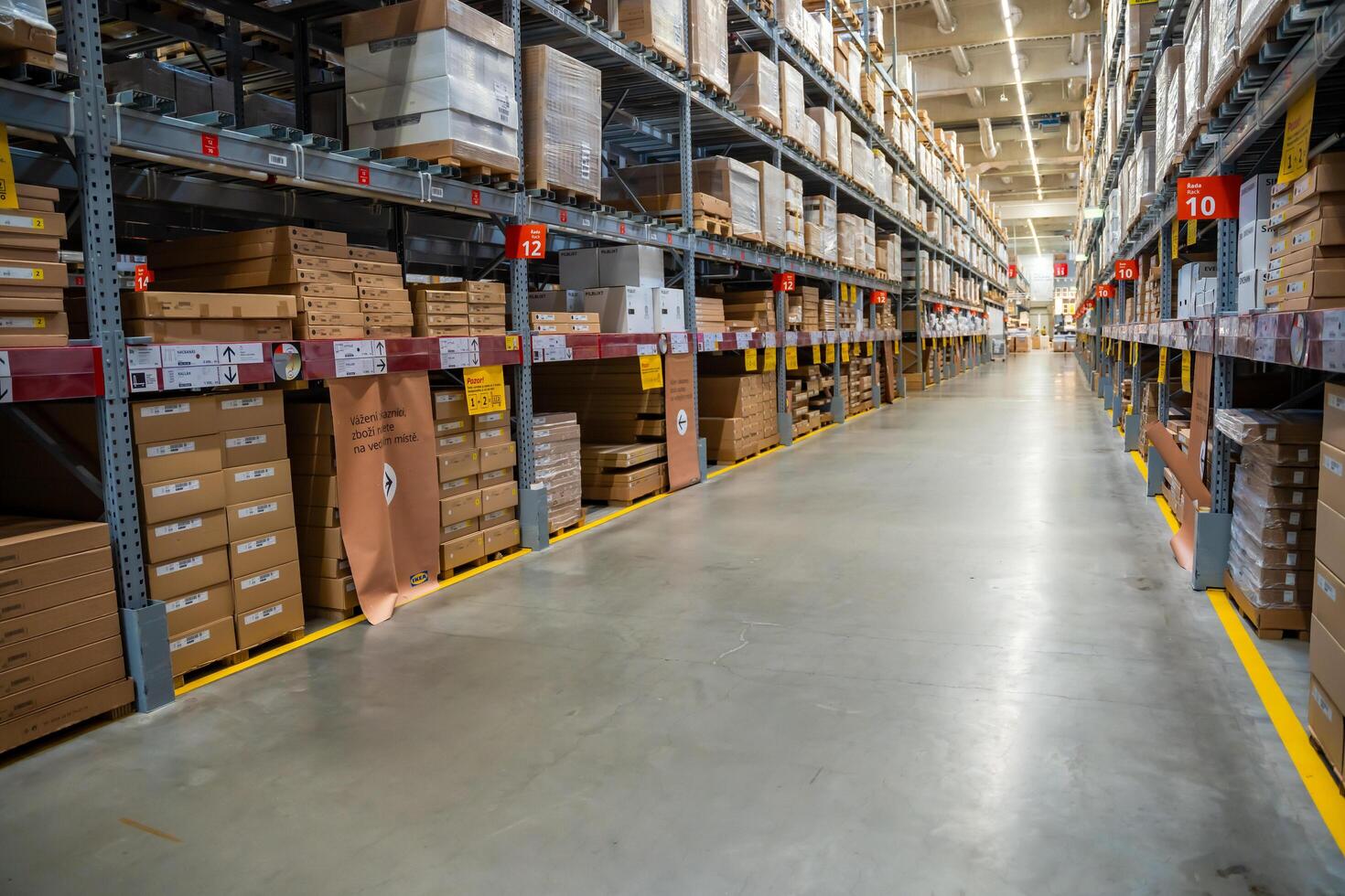 Prague, Czech republic - August 6, 2023. Long shelves with many cardboard boxes with product in warehouse of IKEA . High quality photo
