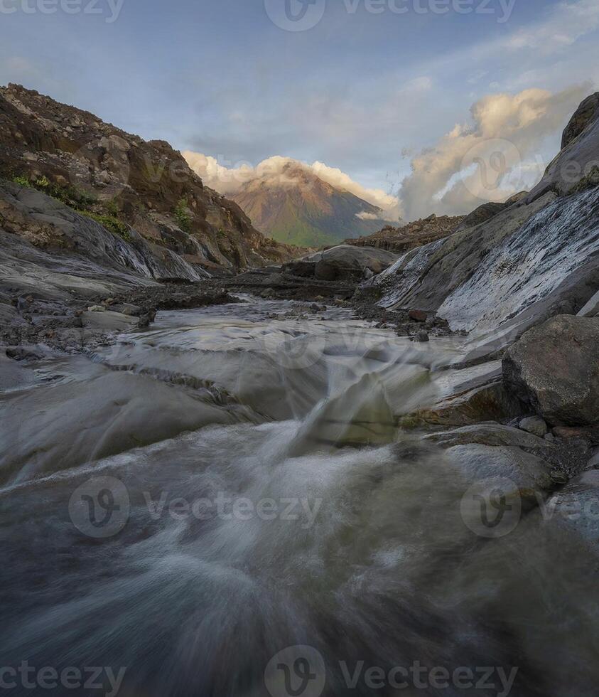 sereno cascada en medio de escénico naturaleza con majestuoso montaña fondo. foto