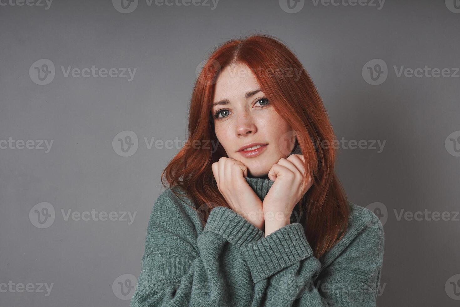 young woman snuggling into warm turtleneck sweater photo